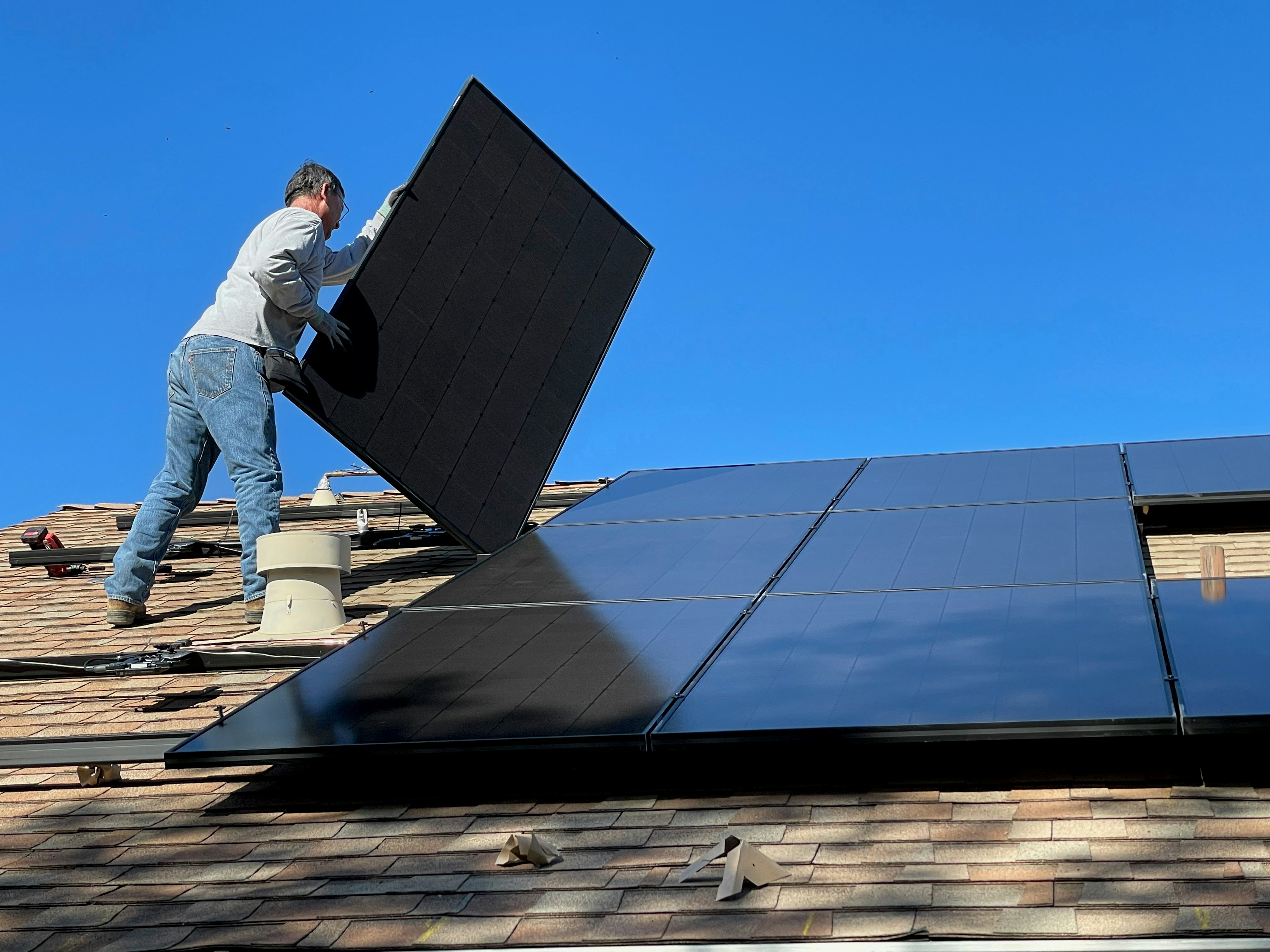 Instalador colocando panel fotovoltaico en cubierta — revisión obligatoria RD 1699/2011